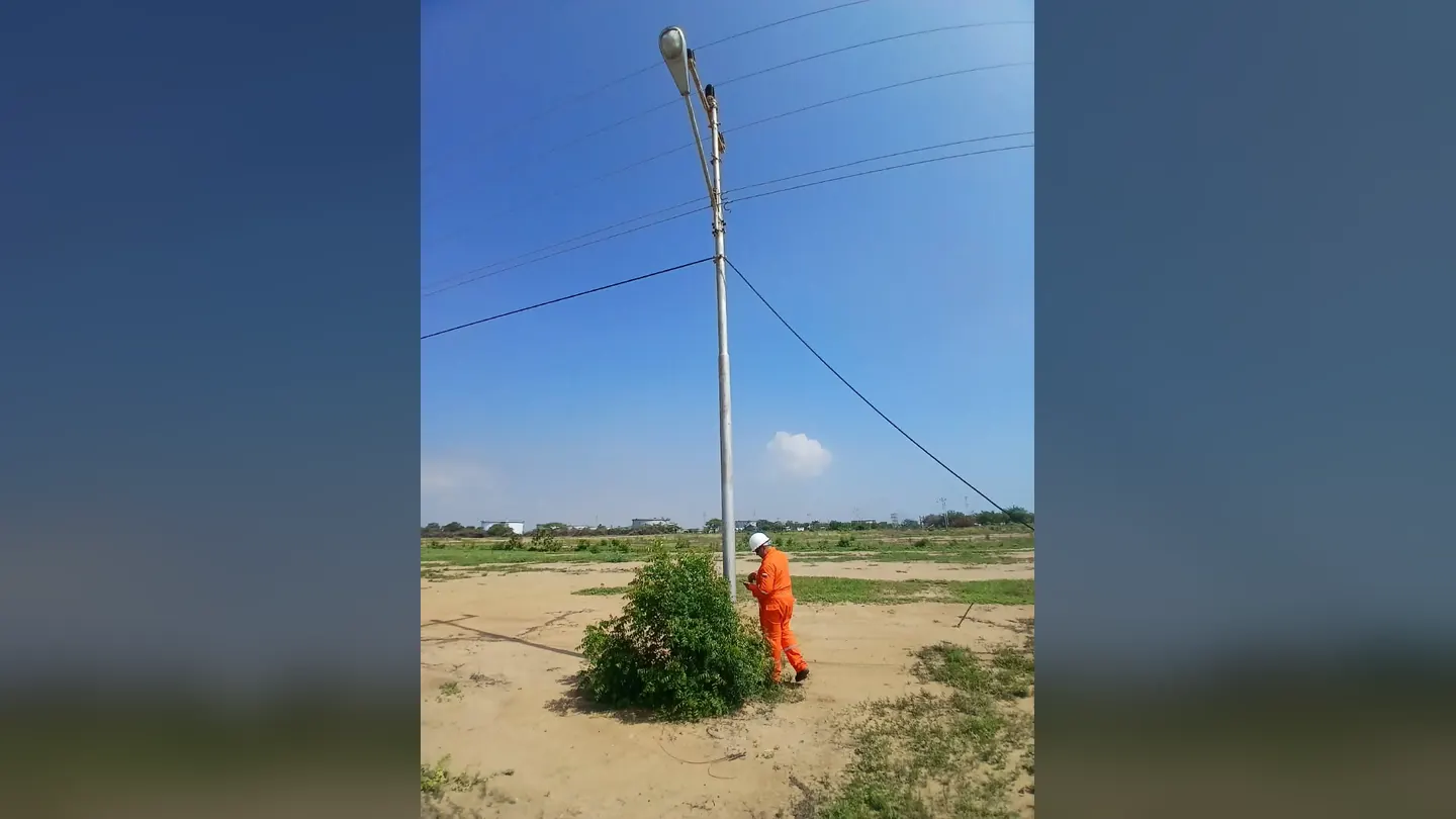 Technician next to a street light pole in the field