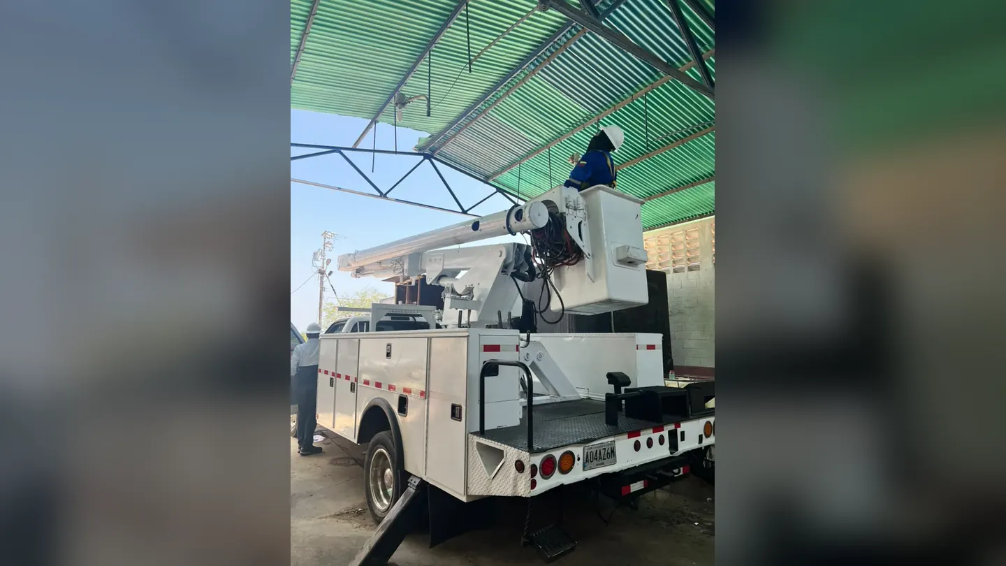 Operario en la cesta de un camión canastilla bajo techo
