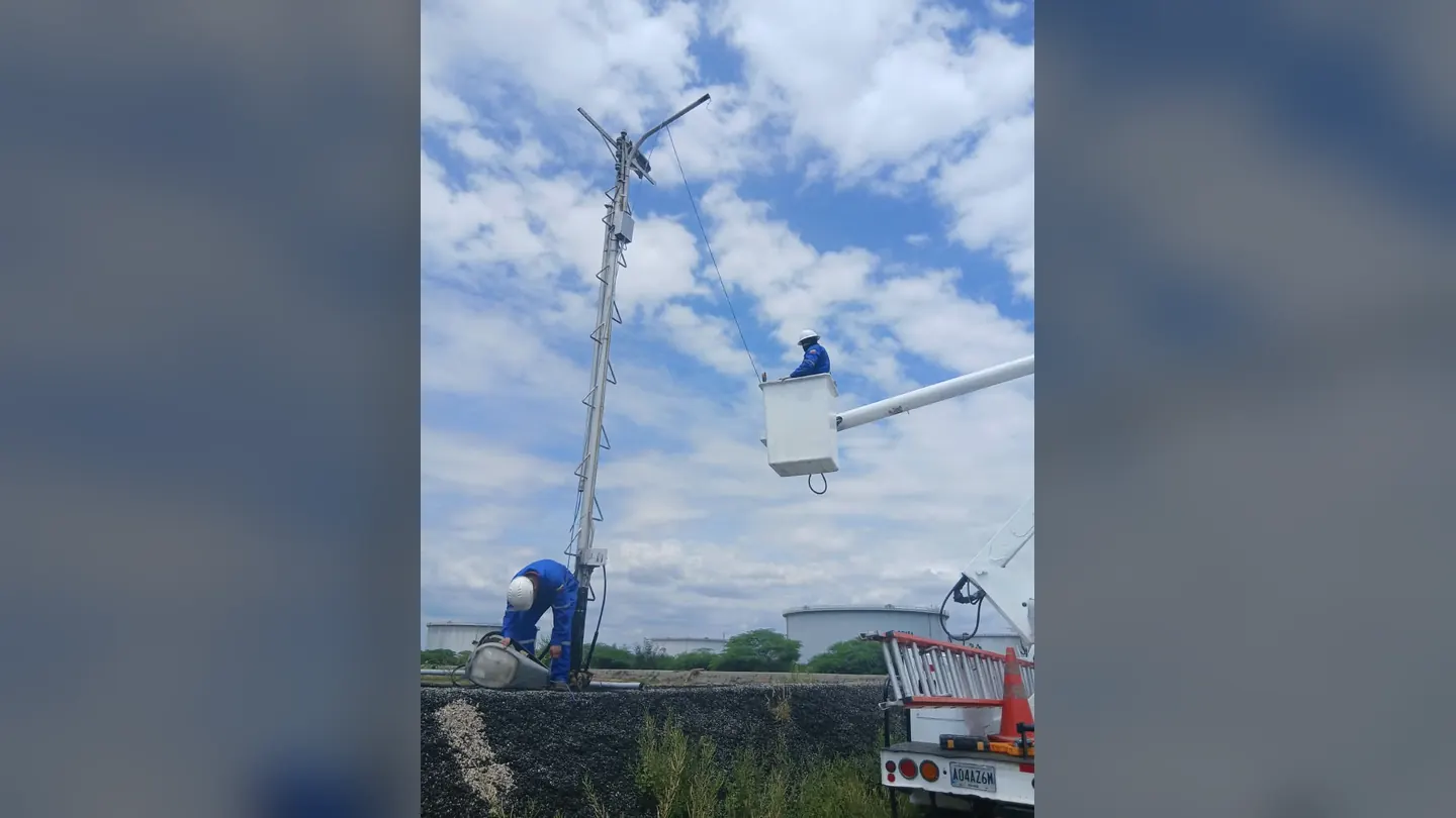 Técnicos instalando una luminaria en un poste