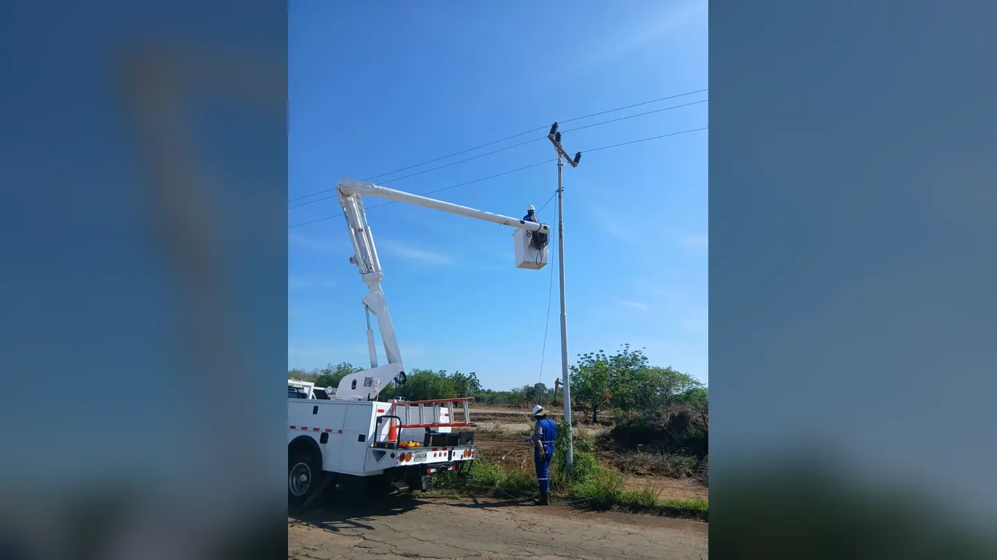 Operario en canastilla trabajando en un poste de alumbrado