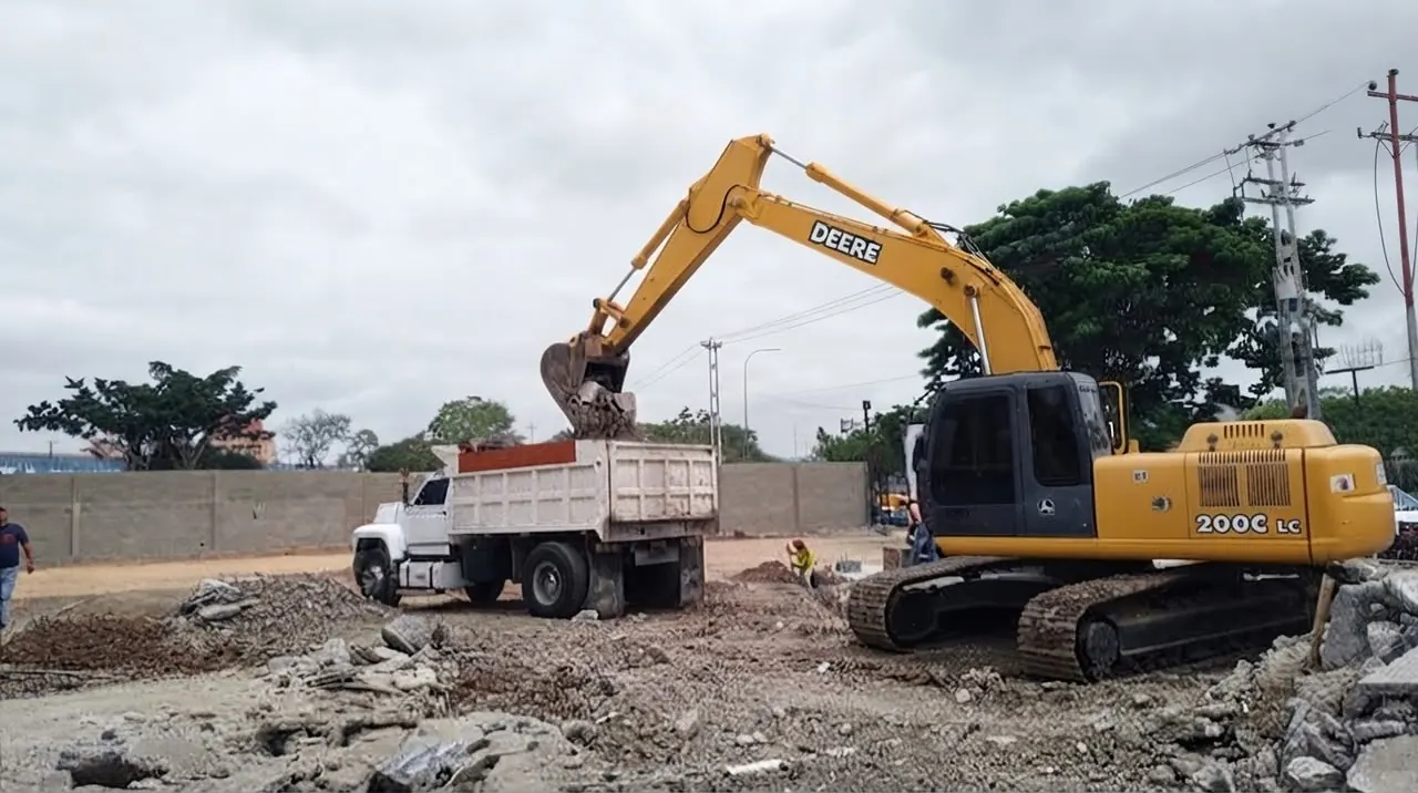 Excavator loading debris into a dump truck