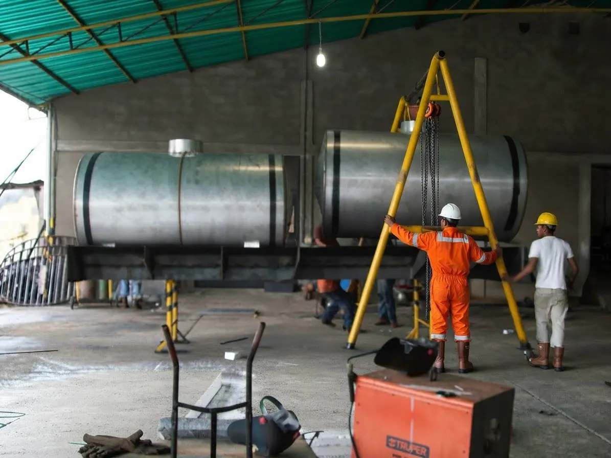 Steel tanks in fabrication with a lifting gantry