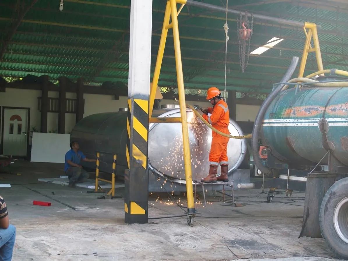 Worker grinding a tanker head