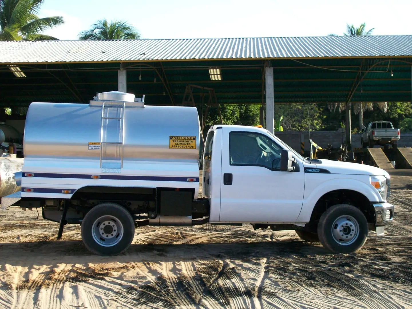 Side view of a truck-mounted stainless steel tank